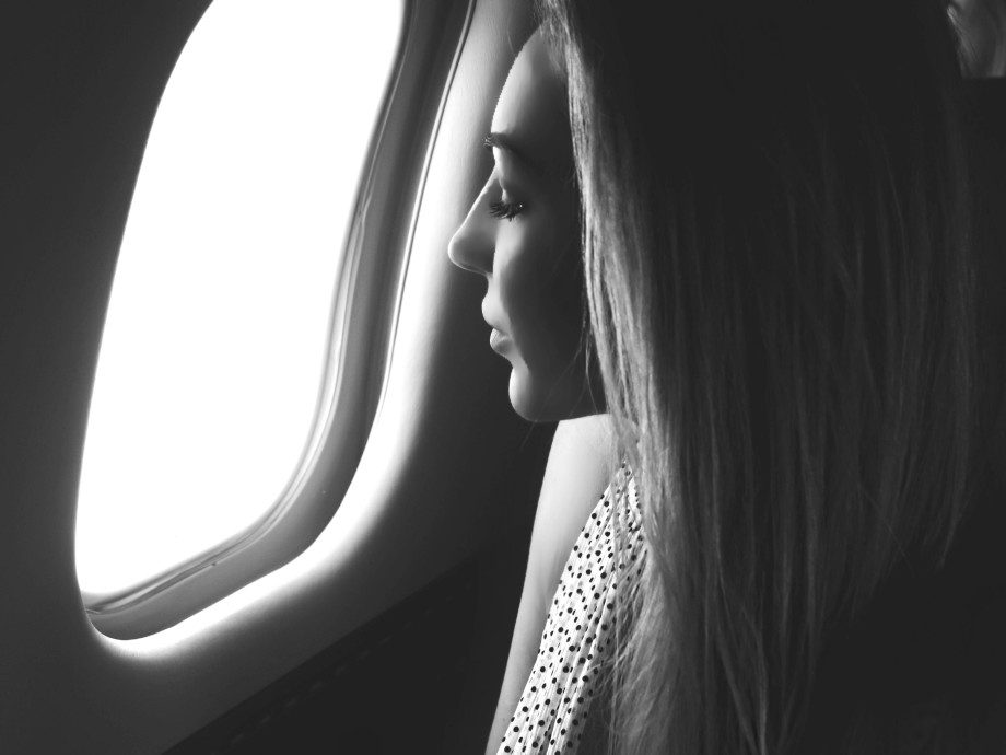 woman looking into the window in a private jet